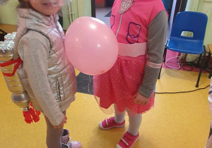 Julka i Zosia tańczą z balonem.